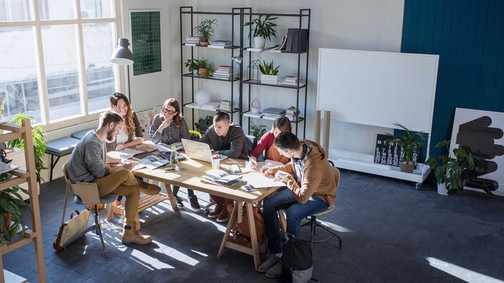 Group of people at a startup sitting around a table networking