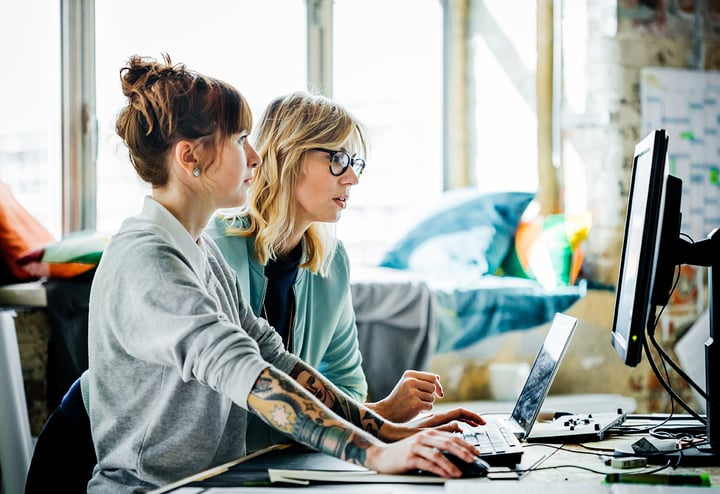 Two Cubeler professional women collaborating on a computer