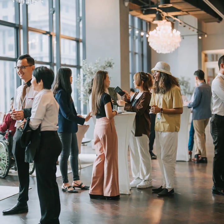 A crowded room filled with people standing together, engaged in conversation and interaction.