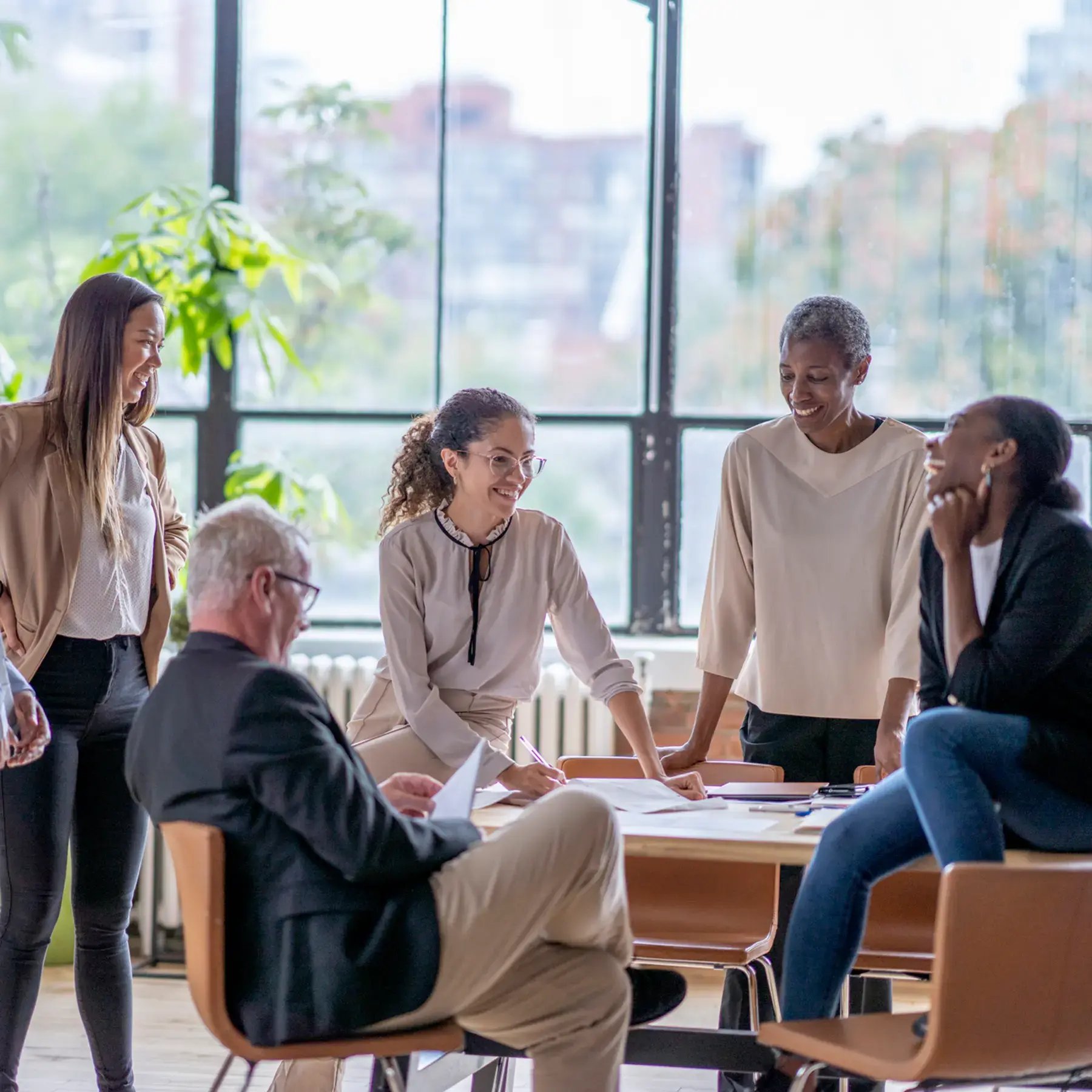 A diverse group of professionals engaged in a collaborative discussion during an office meeting.