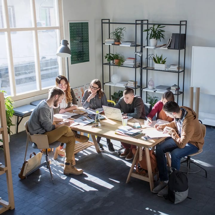 Groupe de personnes dans une startup assises autour d'une table de réseautage.