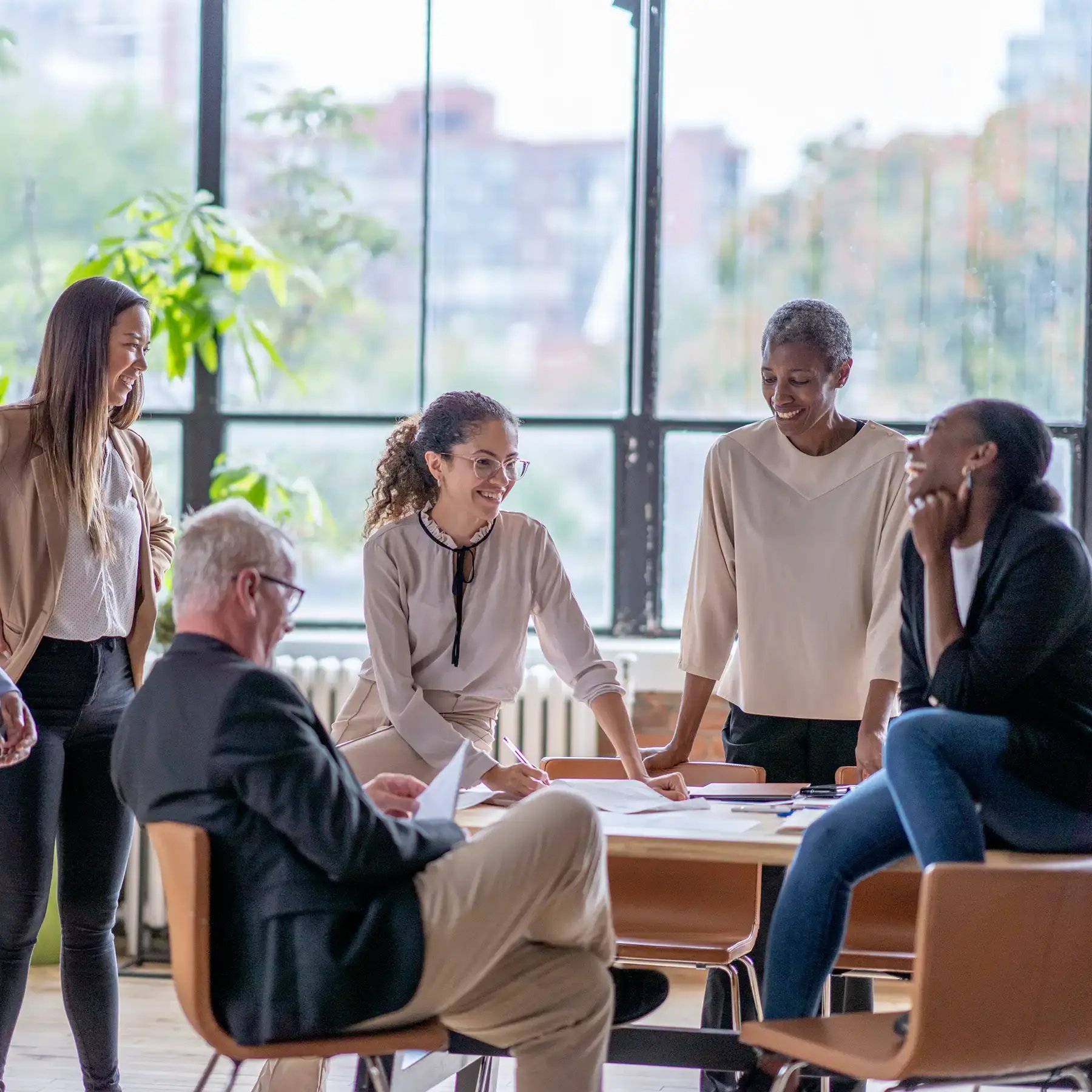 Un groupe diversifié de professionnels engagés dans une discussion collaborative lors d’une réunion de bureau.